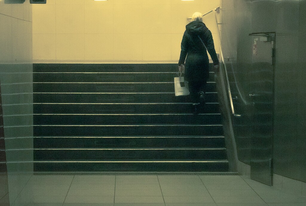 Woman walking up steps in the Berlin Ubahn station, Sean P. Durham, Berlin, 2019. Copyright