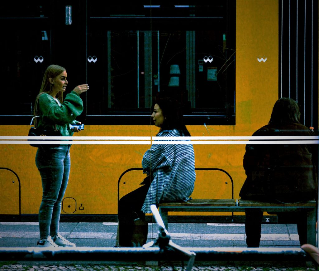 two women chatting at a tram stop in Berlin, Germany. Sean P. Durham, Berlin, 2018