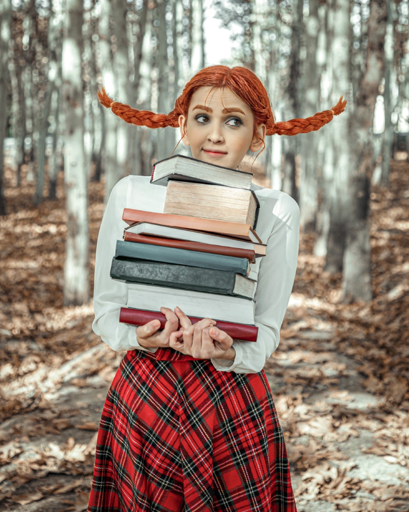 Girl with pigtails and a pile of books, walking through the woods alone.