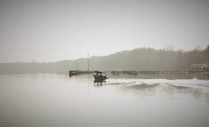Müggelsee with small boat on the misty water. Copyright; Sean P. Durham, Berlin, 2023